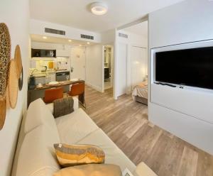 een woonkamer met een bank en een flatscreen-tv bij JP Crauford Hospedagem in Sao Paulo