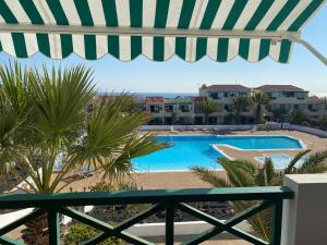 - Balcón con vistas a la piscina en Las Torres del Castillo, 208Marina, en Costa de Antigua