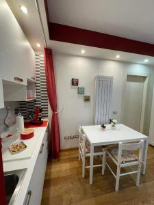 una cocina con una mesa blanca y una cortina roja en B&B La Fisarmonica en Bastia Umbra