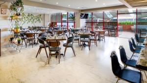 ein Restaurant mit Tischen und Stühlen in einem Zimmer in der Unterkunft Metria Hotel in León