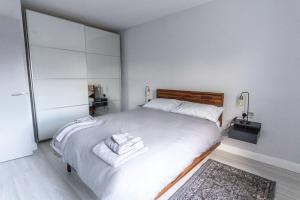 a bedroom with a white bed with towels on it at Causeway Coast Beach Front Apartment - Ballycastle in Ballycastle