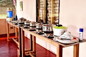 a counter with several pots and pans on it at Sirimane Homestay - Swimming Pool, Food, Near to Falls & Trek in Sakleshpur