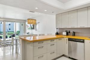 a kitchen with white cabinets and a yellow counter top at Ground Level Pet-Friendly Condo Seconds from Beach in South Padre Island