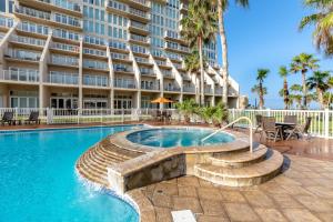 a swimming pool in front of a large building at Ground Level Pet-Friendly Condo Seconds from Beach in South Padre Island