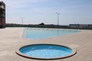 ein großer Pool in der Mitte eines Gebäudes in der Unterkunft Seaven Ericeira Beach Studio in Ericeira