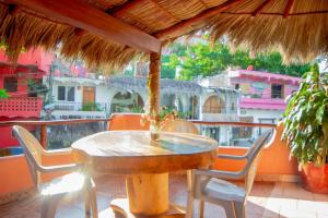 a table and chairs under an umbrella on a balcony at Bungalows Jaqueline in Sayulita