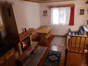 a living room with a fireplace and a table at Karak Apartman in Harghita-Băi