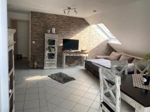 een slaapkamer met een bed en een tv in een bakstenen muur bij Ferienwohnung zum Spessart in Lohr