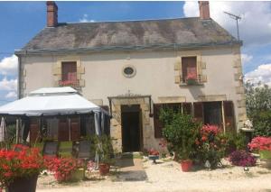 una vecchia casa con dei fiori davanti di Chambres et table d'hôtes les grivottes a Boulleret