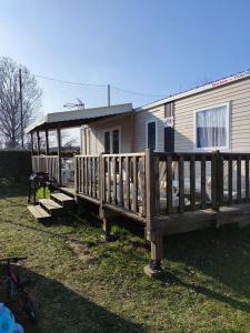 a wooden deck with a gazebo in front of a house at Assist' Mobil home 363 - Charmant mobil home 8 personnes 3 chambres in Onzain