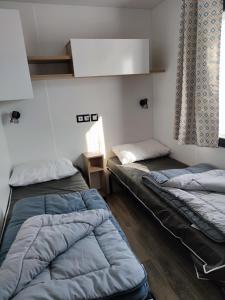 um quarto com duas camas e uma janela em Assist' Mobil home 363 - Charmant mobil home 8 personnes 3 chambres em Onzain