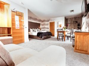 a bedroom with a bed and a dining room at The Tower Gastro Pub & Apartments in Crieff