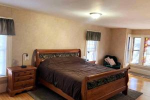 1 dormitorio con 1 cama, vestidor y ventanas en Winnisquam Lake House, en Tilton