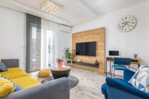 een woonkamer met een bank en een tv bij Apartman Nina in Fažana
