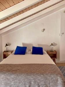 a bedroom with a large bed with blue pillows at Casa no Montinho in Ourique
