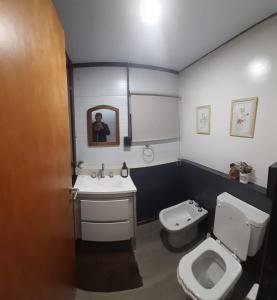 a bathroom with a white toilet and a sink at Cantal Tiny house in Salta