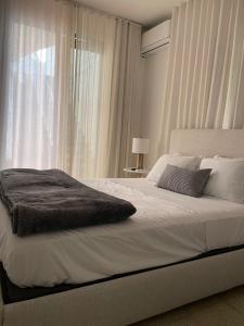 a bedroom with a large white bed with a window at Mar Báltico in San Juan