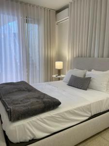 Un dormitorio con una gran cama blanca con ventana. en Mar Báltico, en San Juan