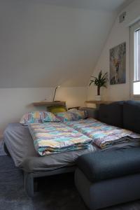 Cama grande en habitación con sofá en Gemütliche Apartments in der Heide en Soltau