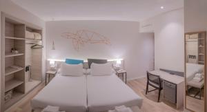 a bedroom with a large white bed and a desk at Hotel Mediterraneo Valencia in Valencia