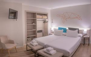 Schlafzimmer mit einem großen weißen Bett und einem Schreibtisch in der Unterkunft Hotel Mediterraneo Valencia in Valencia
