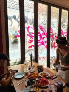 a woman sitting at a table with plates of food at Jetpak Alternative Eco Hostel in Thessaloniki +25 photos