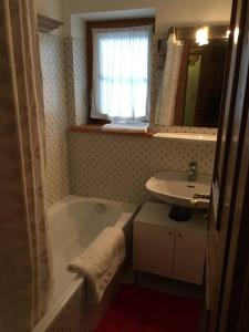 a bathroom with a bath tub and a sink at Gundhabing flat in Kitzbühel