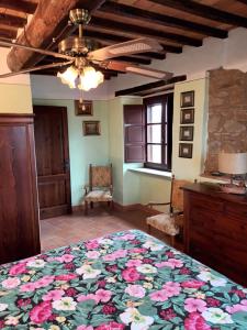 1 dormitorio con 1 cama grande con colcha de flores en Castello di Gaiche, en Collebaldo