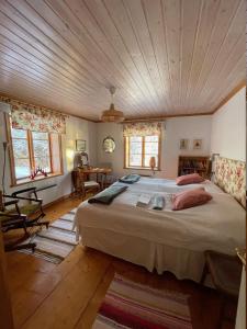 Nordingrå的住宿－Pelle Åbergsgården，一间卧室设有一张带木制天花板的大床
