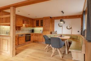 a kitchen with wooden cabinets and a table and chairs at Apartment LISAL by All in One Apartments in Bruck an der Großglocknerstraße