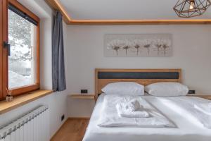 a bedroom with a bed with white sheets and a window at Apartment LISAL by All in One Apartments in Bruck an der Großglocknerstraße