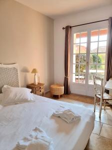a bedroom with a white bed and a window at Castillon Des Baux in Maussane-les-Alpilles