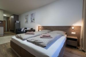 a bedroom with a large bed with towels on it at Apartmány ABIES - Štrbské Pleso in Štrbské Pleso