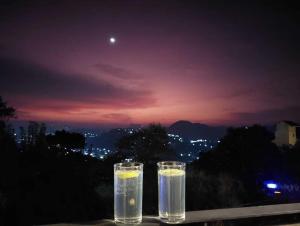 Un par de vasos de agua en una mesa por la noche. en Hotel Kandyan View ''Free pickup from Kandy city'', en Kandy