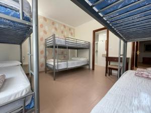 een slaapkamer met 2 stapelbedden en een bureau bij Albergue O Cruceiro in Caldas de Reis