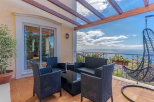 a balcony with chairs and a view of the ocean at Villa Bougainvillea Palheiro Village by HR Madeira in Funchal