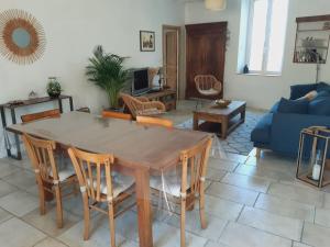 een woonkamer met een houten tafel en stoelen bij Le logis du moulin, à 800m de la cité médiévale in Carcassonne