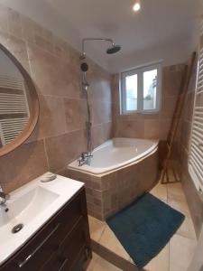 een badkamer met een bad, een wastafel en een spiegel bij Le logis du moulin, à 800m de la cité médiévale in Carcassonne
