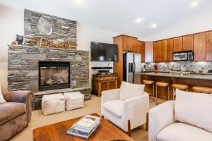 a kitchen and living room with a stone fireplace at Newly Updated Red Slate 4 is a 4 Bedrm 3 full Bathrm Townhome Close to Canyon Lodge That Sleeps 10 in Mammoth Lakes