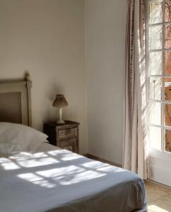 Schlafzimmer mit einem Bett und einem Fenster in der Unterkunft Castillon Des Baux in Maussane-les-Alpilles