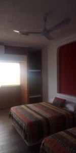 a bedroom with two beds and a ceiling fan at HOTEL VILLAS XAIBA in Puerto Escondido