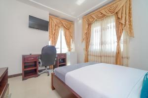 a bedroom with a bed and a desk and a window at Ayenda Yubarta in Buenaventura