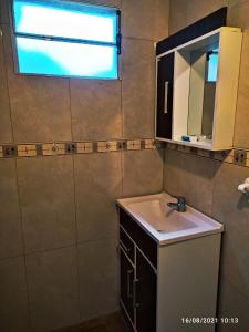 a bathroom with a sink and a mirror and a window at Las Mozitas 1 in Barra del Chuy