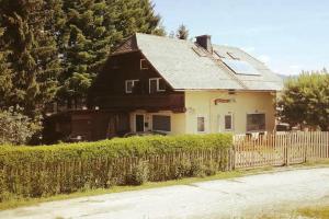 a brown and white house with a fence at Gästehaus Deisl in Mariapfarr