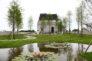 a pond with flowers in front of a building at Haut Rhin Villa in Zhuangwei