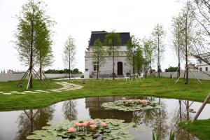 un estanque con flores frente a un edificio en Haut Rhin Villa, en Zhuangwei