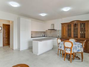 a kitchen with a table and chairs in a room at Belvilla by OYO La casa di Laura in Arzachena