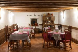 a dining room with tables with red and white tablecloths at Casona Indiana de Ayuelas in Ayuelas