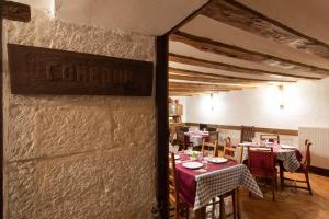 a restaurant with tables and chairs and a sign on the wall at Casona Indiana de Ayuelas in Ayuelas +25 photos