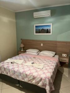 Hotel Vitória في Pedreira: غرفة نوم بسرير كبير مع بطانية وردية
